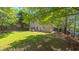Expansive backyard showcasing lush green lawn, mature trees, and a charming patio seating area at 916 Woodside Park Ln, Durham, NC 27704