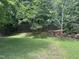 Spacious backyard with mature trees and a wooden fence, offering privacy and natural beauty at 916 Woodside Park Ln, Durham, NC 27704