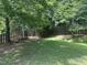 Serene backyard with green lawn and trees, enhanced by a wood fence for added privacy at 916 Woodside Park Ln, Durham, NC 27704