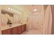 Well-lit bathroom with wood cabinets, an expansive mirror, and neutral flooring at 916 Woodside Park Ln, Durham, NC 27704