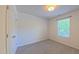 Empty bedroom featuring a large window and neutral-toned carpet at 916 Woodside Park Ln, Durham, NC 27704