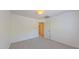 Empty bedroom with carpet, a window for natural light, and a white door at 916 Woodside Park Ln, Durham, NC 27704