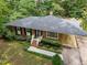 Aerial view of a brick home with a carport and manicured lawn surrounded by trees at 926 Wimbleton Dr, Raleigh, NC 27609