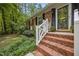 Close up of front entrance, showcasing brick steps, white railing, and well kept landscape at 926 Wimbleton Dr, Raleigh, NC 27609