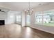 Bright dining area features hardwood floors, modern chandelier, and large windows showcasing the neighborhood at 94 Black Walnut Dr # 201, Garner, NC 27529