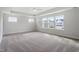 Spacious main bedroom featuring plush carpet, tray ceiling, and large windows for ample natural light at 94 Black Walnut Dr # 201, Garner, NC 27529