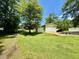 Exterior view shows a spacious lawn and outbuildings on this property at 94 S Waters Edge Ln, Henderson, NC 27537