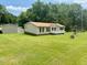 Cozy single-story home with well-maintained lawn, mature trees, and a detached garage at 94 S Waters Edge Ln, Henderson, NC 27537