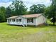 Well-maintained single-story home with a charming front porch and lush green lawn at 94 S Waters Edge Ln, Henderson, NC 27537