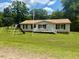 Charming single-story home with a welcoming front porch, a manicured lawn, and mature landscaping at 94 S Waters Edge Ln, Henderson, NC 27537
