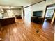 Open-concept living area with wood floors, seamlessly connecting the kitchen and bedroom, for a unified living space at 94 S Waters Edge Ln, Henderson, NC 27537