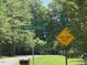 Street sign indicates the property address is on S. Water's Edge Lane, in a wooded area at 94 S Waters Edge Ln, Henderson, NC 27537