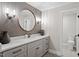 Modern bathroom with a round mirror and stylish tiled accent wall at 9940 Koupela Dr, Raleigh, NC 27614