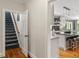 Inviting hallway showcases stairs and kitchen access with hardwood floors and neutral tones at 9940 Koupela Dr, Raleigh, NC 27614