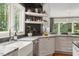 Bright kitchen featuring a farm sink, white cabinets, stone counters, and natural light at 9940 Koupela Dr, Raleigh, NC 27614