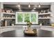 Bright kitchen showcasing floating shelves, neutral stone counters, and backyard views at 9940 Koupela Dr, Raleigh, NC 27614