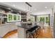 Spacious kitchen with dark island, open shelves, stainless appliances, and hardwood floors at 9940 Koupela Dr, Raleigh, NC 27614