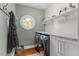 Well-lit laundry room features modern washer and dryer with storage and a unique circular window at 9940 Koupela Dr, Raleigh, NC 27614