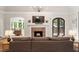 Inviting living room featuring a brick fireplace, hardwood floors, and seamless access to the outdoors at 9940 Koupela Dr, Raleigh, NC 27614