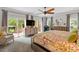 Bright primary bedroom with sliding glass doors to a deck, soft colors, and a ceiling fan at 9940 Koupela Dr, Raleigh, NC 27614