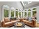 Bright sunroom with arched windows, vaulted ceiling, and comfortable seating for relaxing and entertaining at 9940 Koupela Dr, Raleigh, NC 27614