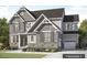 An elegant two-story home featuring a stone facade, complemented by gray shutters and a landscaped front yard at Tbd Lot 11 Montgomery Estates Rd, Hillsborough, NC 27278