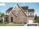 Charming two-story home with brick exterior, arched entryway, and attached two-car garage at Tbd Lot 11 Montgomery Estates Rd, Hillsborough, NC 27278