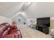 Spacious bonus room with a red leather sofa and mounted television at 10 Oxford Dr, Angier, NC 27501