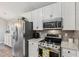 Bright kitchen featuring stainless steel appliances, white cabinetry, and tile backsplash at 10 Oxford Dr, Angier, NC 27501