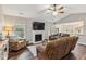 Comfortable living room featuring a fireplace, ceiling fan, and open access to kitchen and dining areas at 10 Oxford Dr, Angier, NC 27501