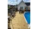 Wooden deck area with lounge chairs overlooking the above ground pool at 10 Oxford Dr, Angier, NC 27501