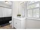 Well-lit bathroom featuring a vanity, a decorative mirror, and a window with louvered shutters at 100 Fountain Springs Rd, Holly Springs, NC 27540