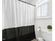 Bright bathroom with a black and white shower curtain and a window with white shutters at 100 Fountain Springs Rd, Holly Springs, NC 27540
