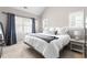 Bright bedroom features two windows, a bed with white comforter, and simple decor at 100 Fountain Springs Rd, Holly Springs, NC 27540