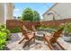 Beautiful backyard fire pit area with Adirondack chairs, stone accents, and charming string lights at 100 Fountain Springs Rd, Holly Springs, NC 27540