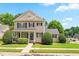 Charming two-story home with a manicured lawn, neat hedges, and classic architectural details at 100 Fountain Springs Rd, Holly Springs, NC 27540