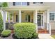 Inviting front porch with brick accents, white columns, hanging plants, and a welcoming wreath on the door at 100 Fountain Springs Rd, Holly Springs, NC 27540