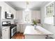 Bright kitchen featuring stainless steel appliances, white cabinetry, and granite countertops at 100 Fountain Springs Rd, Holly Springs, NC 27540