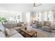 Bright living room with neutral furniture, modern ceiling fan, and hardwood floors at 100 Fountain Springs Rd, Holly Springs, NC 27540