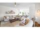 Spacious living room with a large sectional, hardwood floors, and bright lighting flowing into the dining area at 100 Fountain Springs Rd, Holly Springs, NC 27540