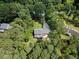 Aerial view of the property showcasing the deck/patio area of the house in wooded back yard at 1005 Enderbury Dr, Raleigh, NC 27614