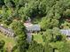 Stunning aerial view of property surrounded by lush trees and an outdoor firepit area with a storage shed at 1005 Enderbury Dr, Raleigh, NC 27614