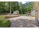 Spacious backyard with a brick patio, cozy fire pit, and a shed surrounded by lush greenery at 1005 Enderbury Dr, Raleigh, NC 27614