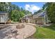Expansive backyard with a brick patio, fire pit, shed, and the rear view of a well-maintained home at 1005 Enderbury Dr, Raleigh, NC 27614