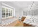 Bright bathroom showcasing a large vanity mirror, soaking tub, and natural light at 1005 Enderbury Dr, Raleigh, NC 27614