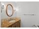 Bathroom with granite counter, wood cabinets, large mirror, and tile backsplash at 1005 Enderbury Dr, Raleigh, NC 27614