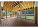 Inviting covered deck with exposed wood ceiling, fan and view of backyard with privacy fence and lawn at 1005 Enderbury Dr, Raleigh, NC 27614