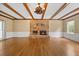 Spacious living room featuring stone fireplace, wood floors, and beamed ceilings at 1005 Enderbury Dr, Raleigh, NC 27614