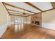 Large living room with a stone fireplace, wood floors, and beamed ceilings at 1005 Enderbury Dr, Raleigh, NC 27614