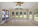 Bright sunroom featuring large windows, a ceiling fan, tile flooring, and access to a back deck at 1005 Enderbury Dr, Raleigh, NC 27614